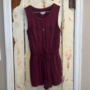 A small maroon buttoned romper that tightens at the waist w/ pockets in the side